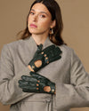 Dark green leather driving gloves with studded button details and finger cutouts