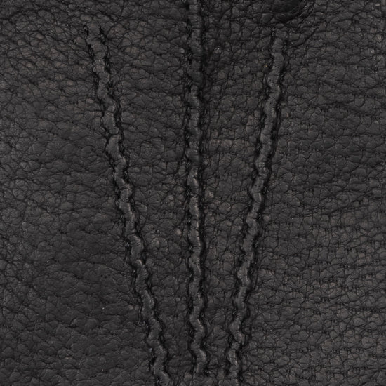 Close-up of textured dark leather glove surface with stitched panel detailing