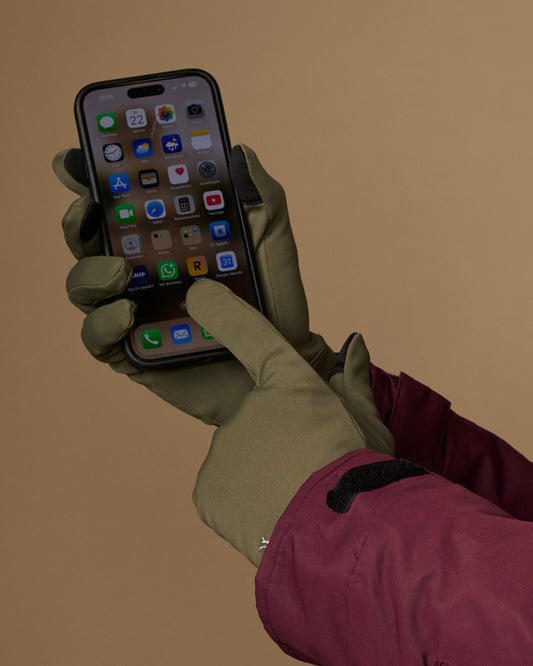 Olive green activity gloves operate a smartphone with touchscreen fingertips