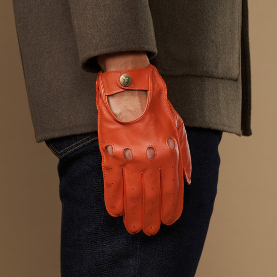 Orange lambskin touchscreen glove, worn at side with thumb opening