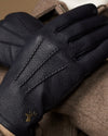 Men's navy leather gloves with wool lining, gold logo and detailed textured stitching