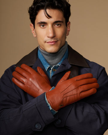Men's cognac goatskin gloves with blue lambswool lining, arms crossed