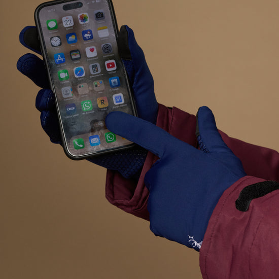 Blue touchscreen activity gloves used to tap a smartphone