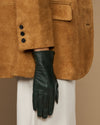 Close-up of dark green leather glove with stitched palm and tapered fingers