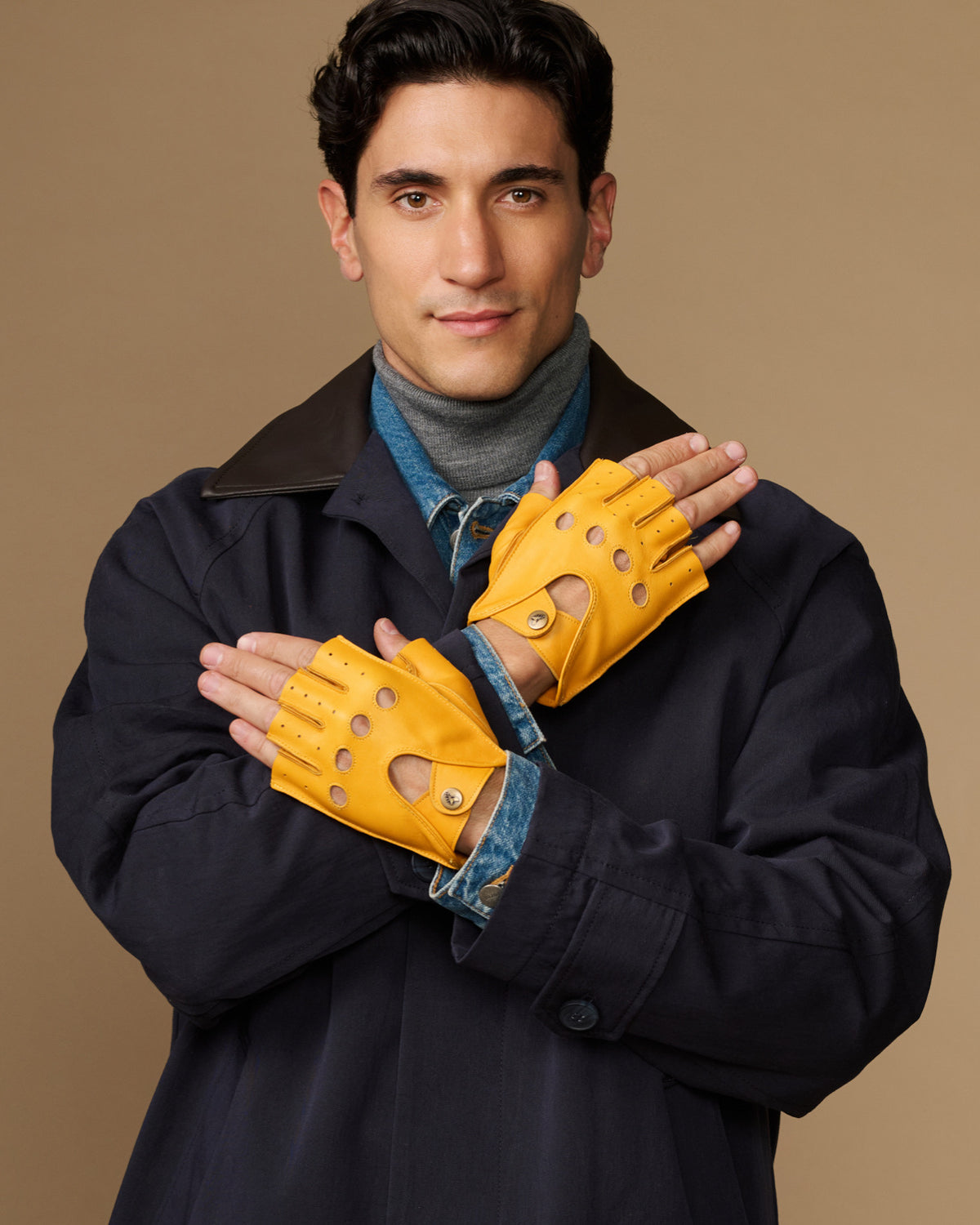 Yellow fingerless driving gloves held together, perforated knuckle details