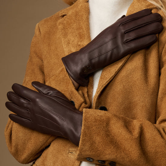 Brown fleece-lined leather gloves, hands raised to show glove shape