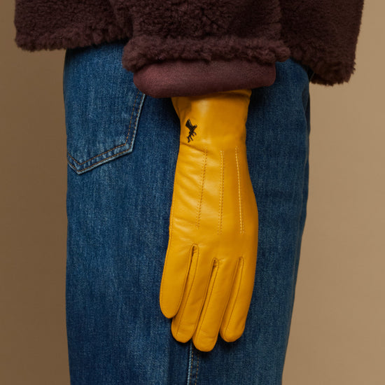 Yellow leather gloves with dark fleece cuff, shown over denim jeans