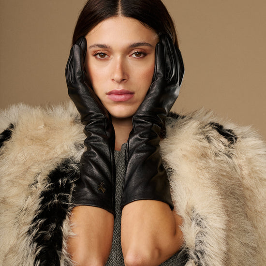 Pair of black below-elbow leather gloves with ruched cuffs, glossy finish, touchscreen fingertips
