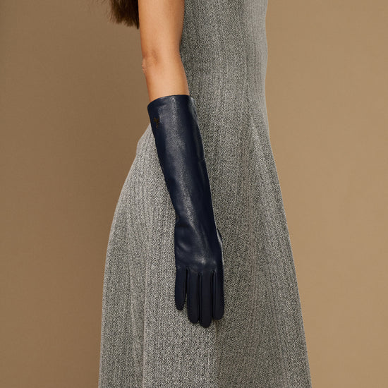 Women’s below-elbow dark blue leather glove on arm, smooth lambskin and snug cuff