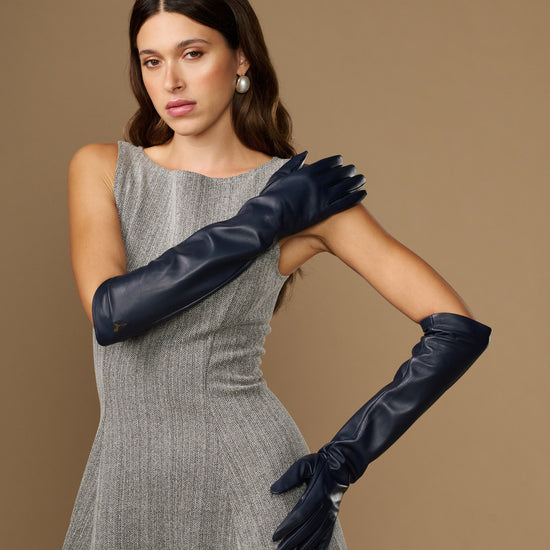 Women's blue leather elbow gloves shown on model, covering upper forearm