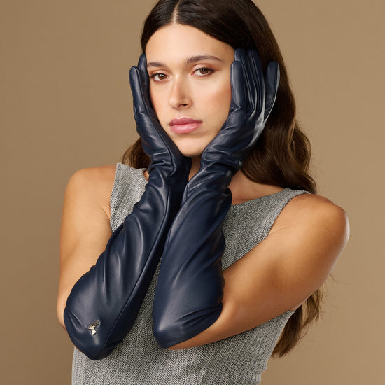 Women's blue leather elbow gloves with neat wrist cuff and close-up hand styling
