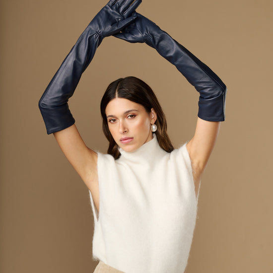 Navy leather opera gloves with long cuffs and silk lining, hands raised overhead