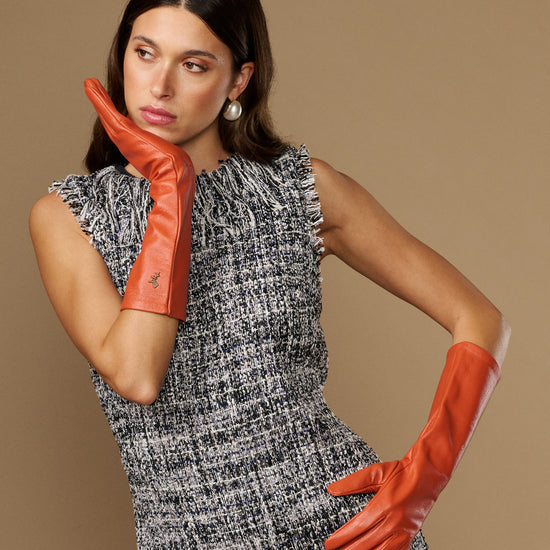 Women’s orange leather gloves with stitched emblem, palm and finger detail