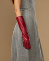 Red leather below-elbow glove on arm, showing long cuff and stitched fingertip seams