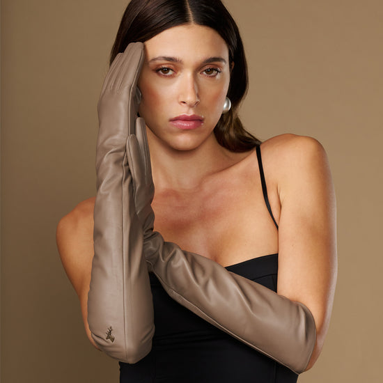 Taupe lambskin elbow-length leather glove close-up near face