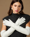 Women's white leather opera gloves with long fingers, hands crossed view