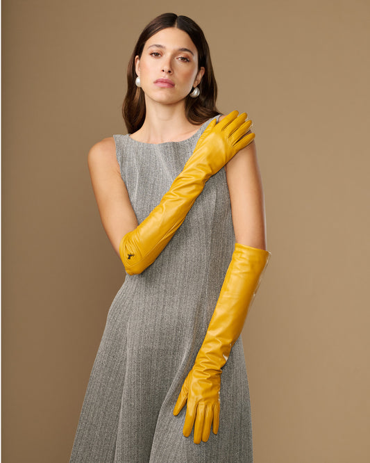 Yellow leather elbow-length gloves with smooth finish and pointed logo on wrist