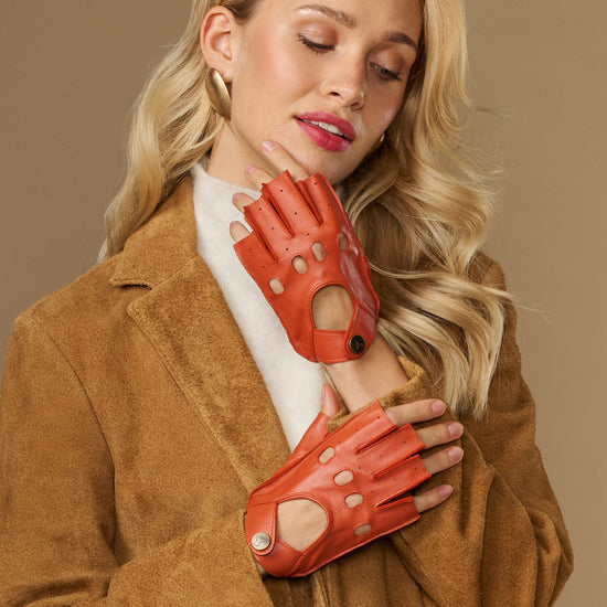 Orange women’s fingerless lambskin driving gloves with studded strap and cutout fingers