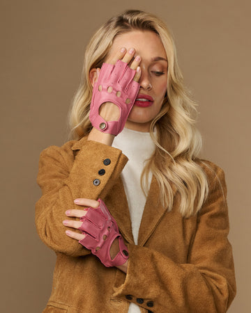 Pink fingerless lambskin driving gloves with snap closures and cutout fingers
