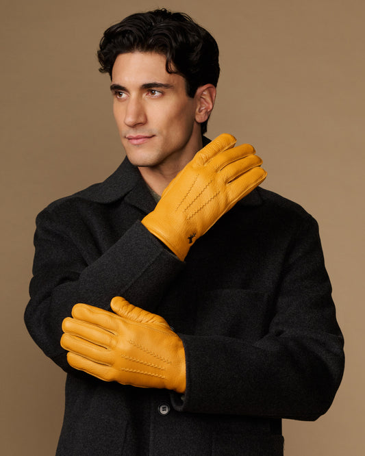 Yellow goatskin leather gloves with stitched details, worn with gray fleece-lined cuffs